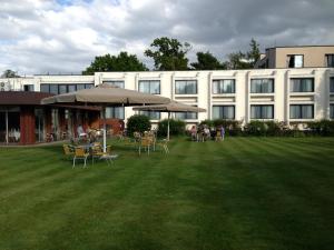 a large building with tables and chairs in a yard at Best Western Ipswich Hotel & Spa in Ipswich