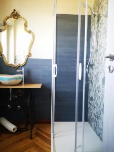 een badkamer met een douche, een wastafel en een spiegel bij Tetto alle Rondini in Cuneo