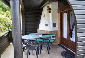 eine Terrasse mit einem Tisch, Stühlen und einer Tür in der Unterkunft Ferienblockhaus Harzidyll in Wieda