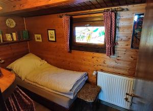 een kleine slaapkamer met een bed en een raam bij Ferienblockhaus Harzidyll in Wieda