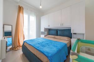 sypialnia z łóżkiem z niebieską kołdrą w obiekcie Babyaccommodation Family Comfort ll w mieście Pietra Ligure