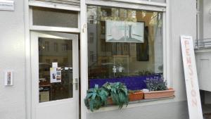 Una ventana de una tienda con plantas. en Pension Friedrich-Wilhelm, en Berlín