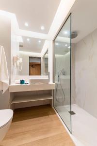 a bathroom with a tub, toilet, sink and shower at Acandia Hotel in Rhodes Town