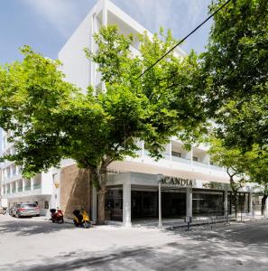 un edificio bianco con un albero di fronte di Acandia Hotel a Città di Rodi