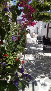 uma passarela com flores ao lado de um edifício em Mare Monte em Chora, Ios