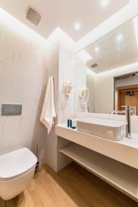 a white bathroom with a sink and a toilet at Acandia Hotel in Rhodes Town