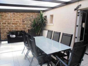a table and chairs in a room with a brick wall at Gîte des Corneilles in Maubert-Fontaine