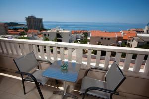 einen Tisch und Stühle auf einem Balkon mit Aussicht in der Unterkunft Apartments Agava in Makarska