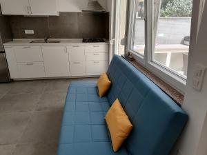 a blue couch with two yellow pillows in a kitchen at Holiday Park Mimoza in Bašanija