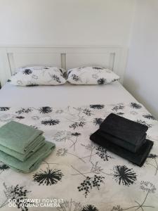 a bed with two pillows and towels on it at Apartments Natalija & Ante in Grebaštica