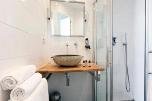 ein Bad mit einem Waschbecken und einer Dusche in der Unterkunft Quentin Golden Bear Hotel in Amsterdam