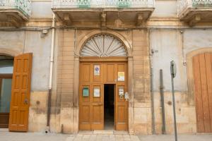 a building with two wooden doors on the side at B&B Santi Medici in Bitonto