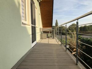 Un balcón de una casa con una pasarela de madera en Am Bahnhof, en Hochkirch