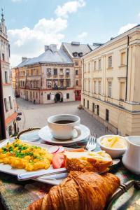 a table with a plate of food and a cup of coffee at Mandragora Apartments 22 in Lublin