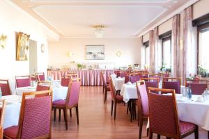 a dining room with white tables and chairs at Hotel Huss Limburg in Limburg an der Lahn