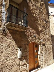 kamienny budynek z drewnianymi drzwiami i balkonem w obiekcie Casa del Pintor w mieście Horta de San Joan