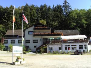 a white building with an american flag in front of it at Hotel Finkenberg in Blankenheim