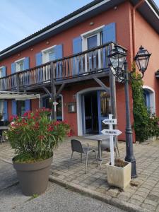 een balkon op een gebouw met een tafel en een straatlamp bij Hôtel Rose des Vents in Baix