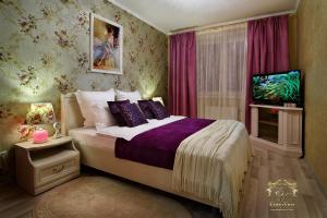 a bedroom with a bed and a tv in it at LIRA EuApartments in Grodno