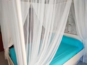 1 cama con cortinas blancas en una habitación en TOSSA MEDIEVO, apartamento a 150 m de la playa, en Tossa de Mar
