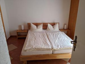 Schlafzimmer mit einem Bett mit weißer Bettwäsche und Kissen in der Unterkunft Hotel Pension Winzerhaus in Bacharach
