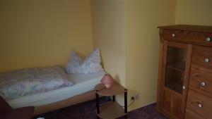 una piccola camera da letto con un letto e una cassettiera di Ferienwohnung Mehlberg a Großlöbichau