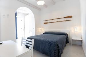 a white bedroom with a bed and a table at B&B White House in Peschici