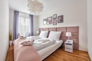 sypialnia z dużym łóżkiem z różowym zagłówkiem w obiekcie Apartamenty Sun & Snow Olymp z basenem w Kołobrzegu