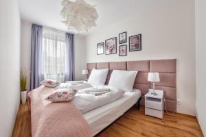 a bedroom with a large bed with a pink headboard at Apartamenty Sun & Snow Olymp z basenem in Kołobrzeg