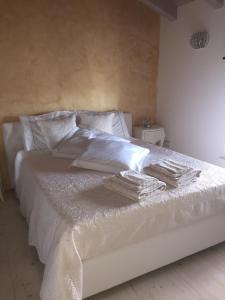 a bedroom with a white bed with white sheets and pillows at La Favorita del Re in Bicinicco