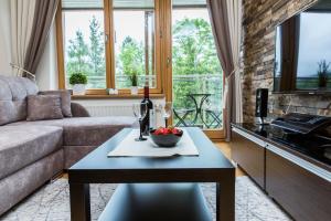 a living room with a couch and a table with a bowl of fruit at Aqua Park Residence in Zakopane