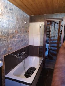 een badkamer met een bad en een douche bij Παραδοσιακός πύργος in Yerolimin