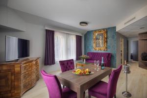 a dining room with a table and purple chairs at Kehida Termál Resort & Spa in Kehidakustány