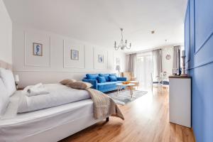 a bedroom with a large bed and a blue couch at Apartamenty Sun & Snow Olymp in Kołobrzeg