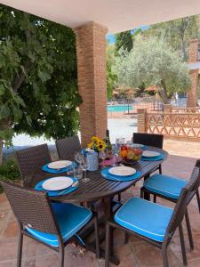 a wooden table with chairs and a table with food on it at Padre Aviles in Olías