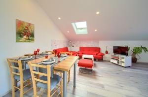 salon ze stołem i czerwoną kanapą w obiekcie Apartment Milena by El-Pi Tours w mieście Nijvice