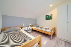 sypialnia z 2 łóżkami i szafką nocną oraz łóżko sidx sidx sidx sidx w obiekcie Apartment Milena by El-Pi Tours w mieście Nijvice