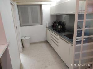 una piccola cucina con armadi bianchi e lavandino di CIRO QUOVADIS a Roma Altre 13 foto