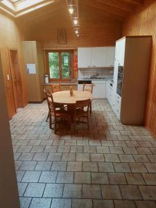 een keuken met een tafel en stoelen en een koelkast bij Apartment in Brienz in Brienz