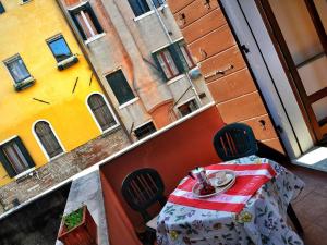 Cà Dolce في البندقية: طاولة وكراسي على شرفة من المبنى