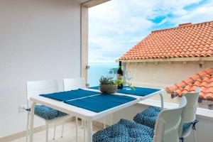 uma mesa e cadeiras numa varanda com vista para o oceano em TopHill Deluxe em Dubrovnik
