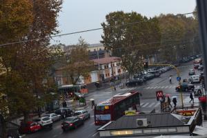 una trafficata strada cittadina con auto e autobus di CIRO QUOVADIS a Roma