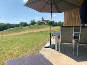 een patio met een parasol en een tafel en stoelen bij Apartment am Weinberg in Ehrenhausen