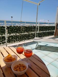 un tavolo con due bicchieri di vino e una ciotola di cibo di Incantevole casa sul mare vicino a Roma a Nettuno