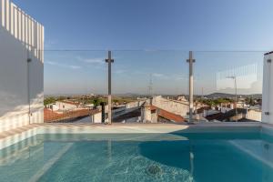 a large swimming pool with a view of a city at CASA d’OLIVENÇA in Elvas