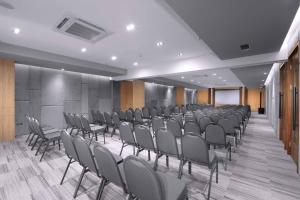 uma sala de conferências com filas de cadeiras e um pódio em Neo Hotel Puri Indah em Jakarta