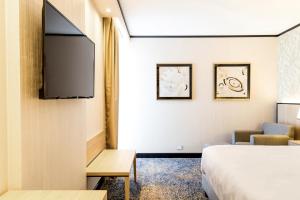 a hotel room with a bed and a flat screen tv at Holiday Inn Rosario by IHG in Rosario +117 photos