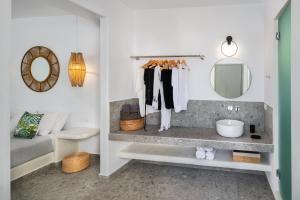 a bathroom with a tub, toilet, sink and mirror at Seven Suites in Imerovigli
