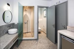 a bathroom with a sink, toilet and shower at Seven Suites in Imerovigli