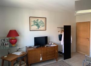 uma sala de estar com televisão num armário de madeira em B&B - Chambres d'hôtes Le Foch em Avignon